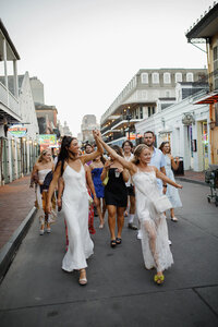 A photo of a bridal party and group walking the streets on New Orleans 
