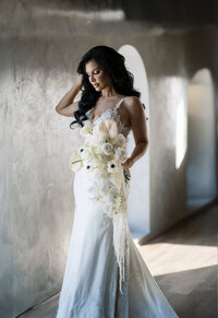 A shot of a bride walking towards the camera with big classic waves holding her bouquet.