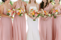 Bridesmaids with their beautiful bouquets posing with a bride on her wedding day