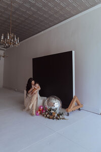 Casual family portrait with photography studio props and a black backdrop