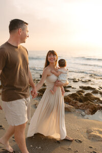 Pregnant woman in jeans with sun beaming behind her.