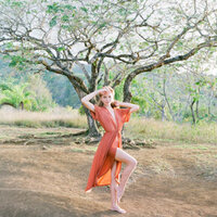 Styled shooting with a beautiful woman in Tahiti wearing an orange dress
