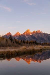 Sunset over the Teton mountain range reflected in the water at Schwabacher Landing near Jackson Hole, photographed by a Colorado and Wyoming wedding photographer.