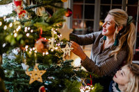 Mom and daughter decorating the  Christmas tree