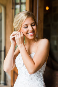 Bride putting her earrings in on her wedding day at Gervasi vineyard photographed by akron ohio wedding photographer