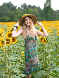 GRADUATING SENIOR GIRL IN A FIELD OF SUNFLOWERS