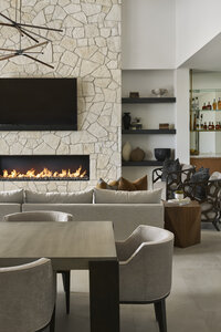 JSF Design fireplace with stone surround, custom shelving, and integrated dining space