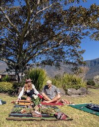 Relationship and intimacy coach sitting on a blanket with husband at a retreat