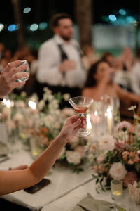 A playful and celebratory engagement moment in downtown Dallas, featuring a couple popping champagne and toasting against the city lights.
