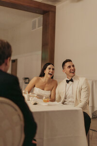 Bride and groom laugh during the speeches