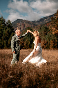 A couple dancing in a field in front of whiteface mountain in upstate NY