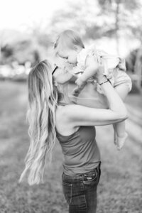 Mother holding baby girl in Downtown Dunedin for Tampa Fall mini session.