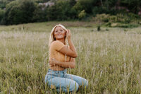 A person crouched down in a field with their arms around each other