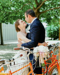 Bride wraps her arms around Groom and smiles looking up at him