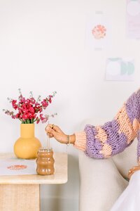 Revolviendo el café, con flores de fondo