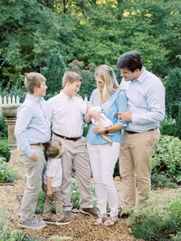 A family smiling at a baby held by the mother at a Richmond newborn photography session by Katie Stansfield Photography.