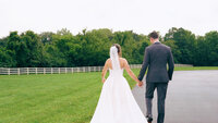 Bride and groom  walking holding hands at Rolling Meadows Ranch in Lebanon Ohio