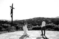 bride-in-front-of-cross-in-black-and-white-at-luxury-destination-wedding-in-sainte-maxime-french-riviera-by-leslie-choucard-photography