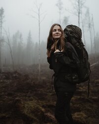 Beccsla Rebecca Knutson går med ryggsäck i skogen.