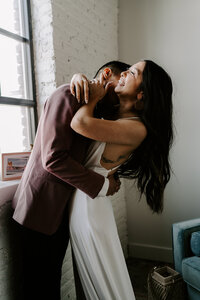 A couple embraces during indoor couples portraits.