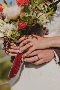 A newlywed couple shows off their rings together
