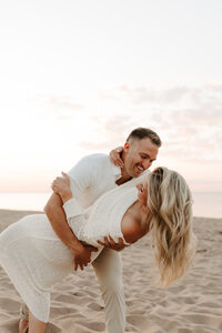 Bride wrapped in grooms arms during engagement photo in Halifax NB