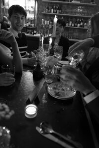 Reception guests at a wedding, dutch angle shot of the table in black and white with finished plates and drinks.