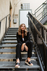 high school senior sitting on stairs outside during her Stylish senior photos Milwaukee