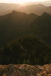 Mountains in the distance with the sun shining through, representing the role of nature in self growth and wellness.