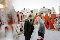 A couple looks at one another during a Neon Museum elopement in Las Vegas