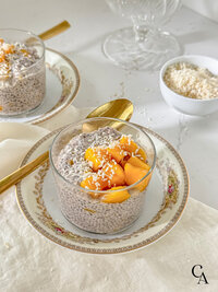A cup of mango chia seed pudding with a gold spoon.