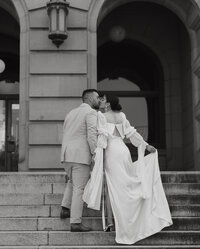 Couple kissing while walking up courthouse steps