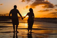 Couple holding hands walking on a beach, symbolizing relationship coaching and connection