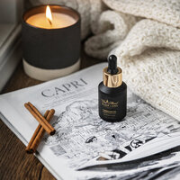 Branding photos for Oils. Oil bottle sitting on a magazine with cinnamon and a candle burning in the background.