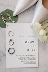 wedding details like rings and shoes with the invitation
