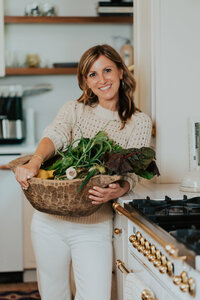 Sam holding a bowl of vegetables in her kitchen