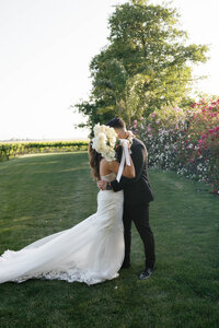 groom picking up bride wearing a cowboy hat