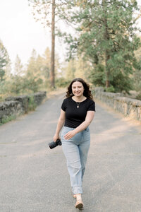 female photographer holidng camera with focus on shirt with logo on it taken by spokane family photographer