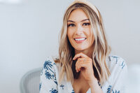 A girl wearing white shirt is smiling