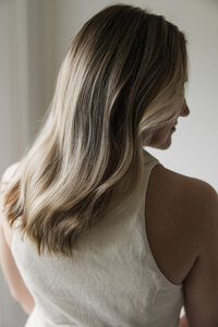 woman with beautiful buttery blonde hair in very soft waves facing away from the camera 
