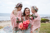 Photo of  Bride with her flower girls. Bright coloured flower bouquests.