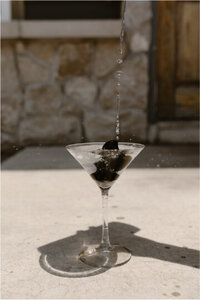 brand shot of dropping onyx magic mushrooms in martini glass