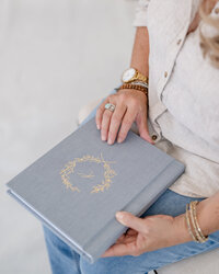 Elegant blue linen heirloom photo album with a custom botanical embossing, photographed in natural light as part of Little Palm's luxury printed photography experience in Northern California.