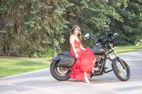Girl in a red dress sitting on a motorcycle.