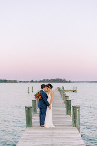 Sunset image of bride and groom on dock