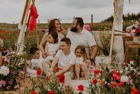 Hélène et sa famille dans un décor champêtre avec coquelicots rouges lors d'une séance photo famille en Vendée.