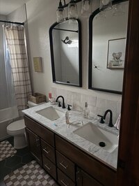 Modern bathroom with twin mirrors and wood cabinetry styled by KSC Interiors.
