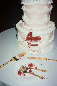 Non-traditional cake cutting featuring a pink two tiered red velvet cake with gold/rose-gold forks and utensils | SushDigitalMedia