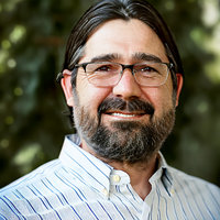 man with glasses and a beard wearing a plaid shirt