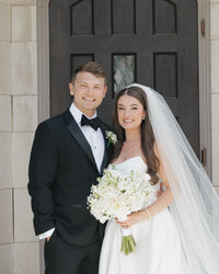A bride and groom smile for their wedding portrait at a wedding in Grand Rapids